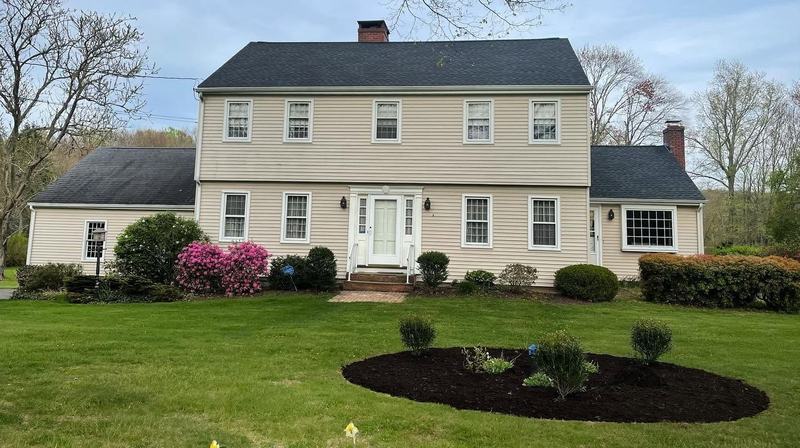 Colonial home with a fresh mulch ring and trimmed shrubs