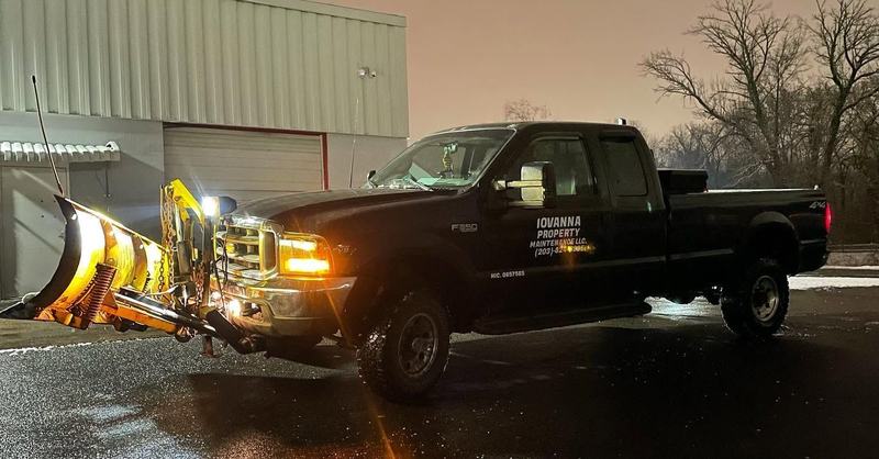 Iovanna plow truck lit up at night before a storm